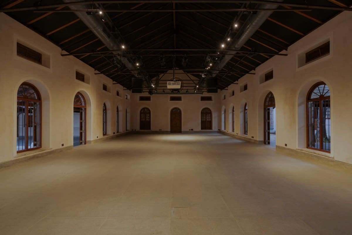 The hall at Sabha: a long room with arched doorways down both sides and an open timber roof
